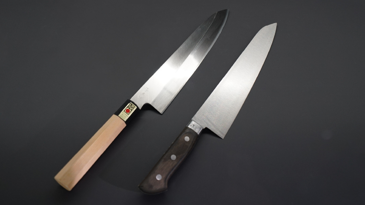 Two Japanese chef’s knives, a traditional wa-handle gyuto and a western-style chef’s knife, on a dark background.