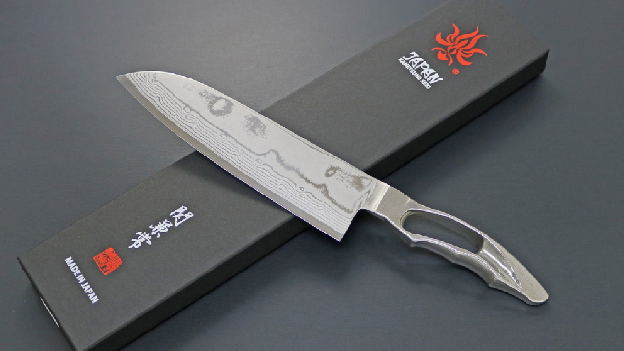 Japanese Damascus kitchen knife resting on a black package box with the Sannoike logo.