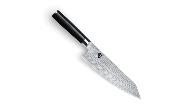 Shun Japanese chef’s knife with black handle and Damascus-pattern blade on a white background.