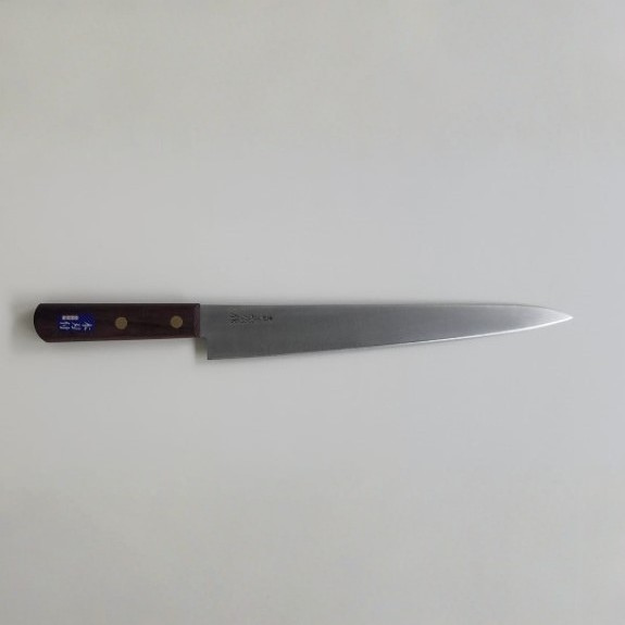 Long kitchen knife with a wooden handle on a light gray background