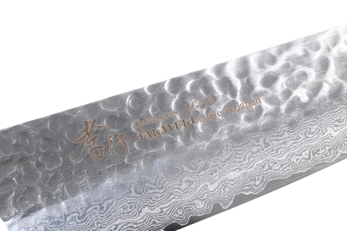 Close-up of a Damascus steel knife blade with engraved text on a white background