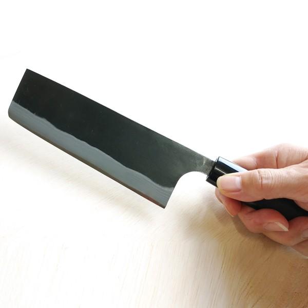 Person holding a kitchen knife on a white background