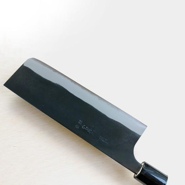 Black cleaver knife on a light wooden surface