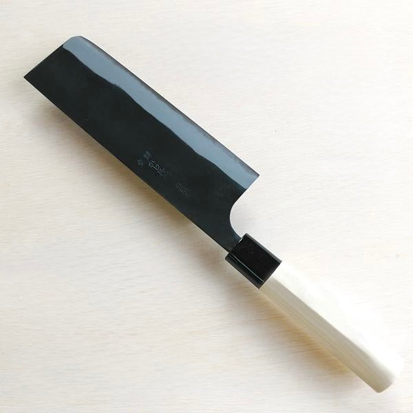 Black cleaver knife on a light wooden surface