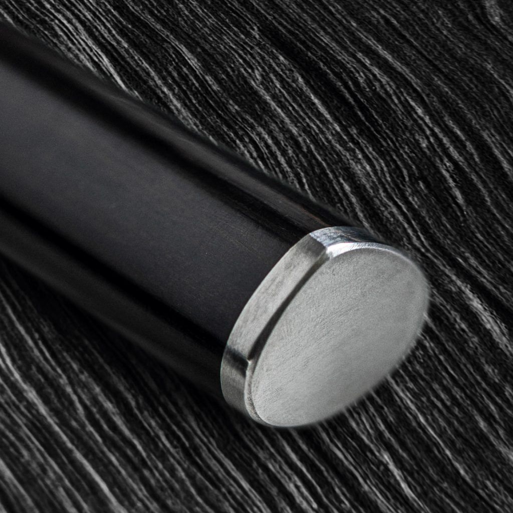 Close-up of a black handle with a metallic edge on a textured dark surface